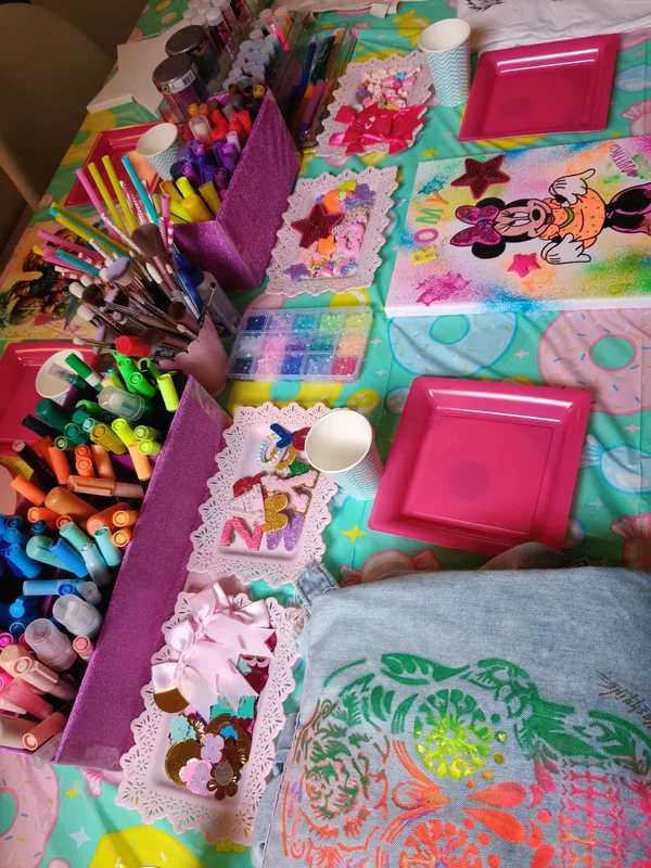 La table de l'atelier : feutres, pinceaux, paillettes et créations en cours